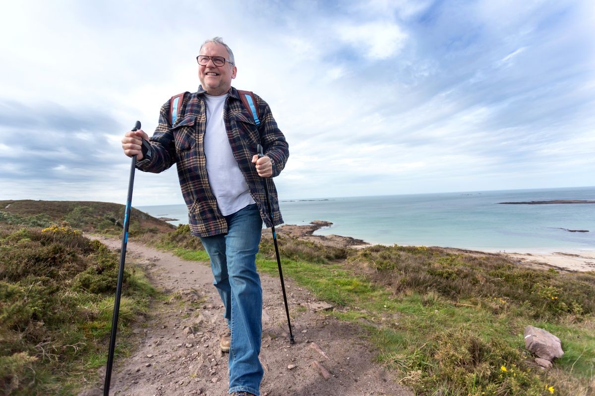 Portrait view of a healthy senior attractive man hiking along the cost 